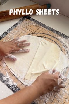 a person kneading dough on top of a table