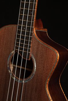 a close up of an acoustic guitar on a black background with the strings still attached