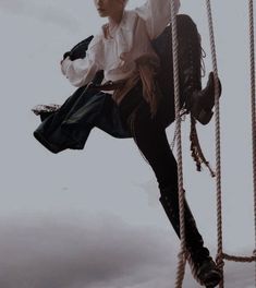 a woman in white shirt and black pants on a rope