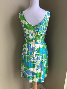 Eye catching floral sleeveless dress by Peck and Peck of Fifth Avenue New York. This 1950's dress has a cotton lining and is in great condition with one small spot on bow. Please view pictures. This well made dress is prefect for any event this summer.  Colors are turquoise, periwinkle, lime green and white.  This would be considered a Small. The fabric is woven and does not stretch.  Additional Detailscontent:  Rayon, Cotton lining. * Note: metal zipper has been replaced with plastic zipper.Mea Mid-century Floral Print Dress For Spring, Mid-century Floral Print Spring Dress, Green Lined Vintage Dress For Summer, Green Lined Vintage Summer Dress, 1950s Style Sleeveless Green Dress, Sleeveless Vintage Dress With Vintage Pattern, Sleeveless Vintage Dress With Pattern, Spring 1950s Vintage Pattern Dresses, 1950s Style Spring Dresses With Vintage Pattern