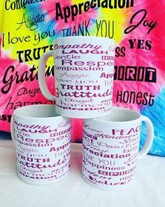 three coffee mugs sitting on top of a table next to a tie - dyed wall