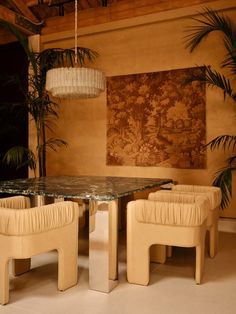 a dining room table with four chairs and a chandelier hanging from the ceiling