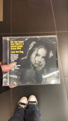 a person holding up a cd in their left hand, with the cover pulled off