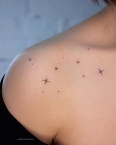 the back of a woman's shoulder with small stars on her left arm and chest