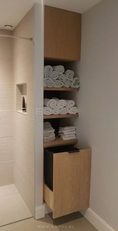 the bathroom is clean and ready to be used as a storage area for folded towels