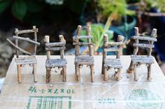 a group of miniature chairs sitting on top of a wooden table