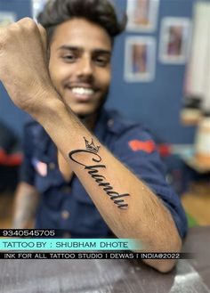 a man sitting at a table with a tattoo on his arm that says,'love you