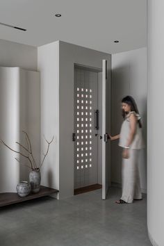 a woman standing in front of a door with lights on the side and behind her