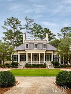 a large white house surrounded by trees and bushes