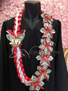 a black graduation gown with red, white and silver ribbon around it's neck