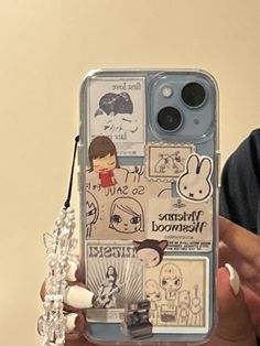 a person holding up a cell phone case with stickers on the back and sides