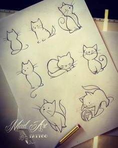 several drawings of cats sitting on top of a piece of paper with a pencil next to it