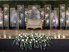 an elaborately decorated stage with flowers and candles on the side, surrounded by glass vases