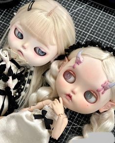 two dolls are laying next to each other