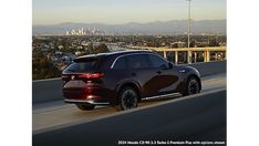 a black suv driving down a highway with the city in the background