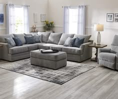 a living room filled with furniture and a large rug on top of a hard wood floor