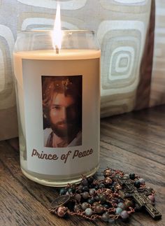 a candle that is sitting on a table next to some rosary beads and a cross