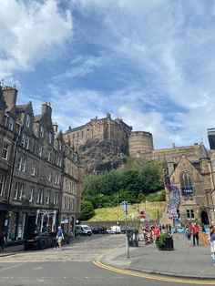 people are walking on the street in front of some old buildings and castle like structures