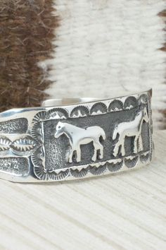 This sterling silver bracelet was made by Navajo silversmith Emerson Kinsel. The inside is signed K and stamped sterling.Size: 5 1/2" (will fit up to a 6 3/4" wrist)Gap: 1 1/4"Length: 7/8"Free shipping on all orders! We ship with USPS and always include tracking. All orders ship within a day of payment.Returns are accepted up to 30 days after you receive your order. Just send us a message. Our shop offers cash back or store credit. The item must be returned in new condition. Artisan Silver Bracelet With Stamped Details, Silver Southwestern Style Bracelet With Oyster Clasp, Southwestern Sterling Silver Cuff Bracelet In Silver, Artisan Sterling Silver Bracelet Nickel-free, Handmade Western Sterling Silver Cuff Bracelet, Stamped Sterling Silver Bangle Bracelet, Southwestern Sterling Silver Cuff Bracelet, Artisan Sterling Silver Nickel-free Bracelet, Artisan Sterling Silver Bracelet, Nickel Free