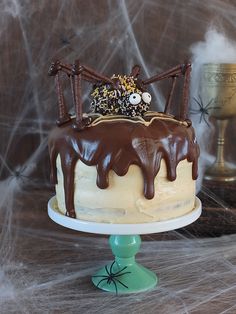 a cake with chocolate icing and sprinkles on top sitting on a table