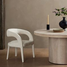 a table with two chairs and a vase on it, next to a candle holder