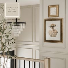 a living room with white walls and framed pictures on the wall, along with a chandelier