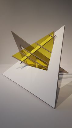 an abstract piece of art that looks like a paper airplane origami plane is on display