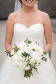 a bride holding her bouquet in front of the camera