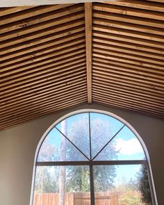 an arched window with wooden slats on the ceiling