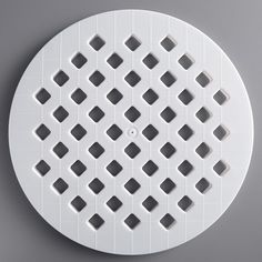 a white circular object with squares and dots on it's surface, against a gray background