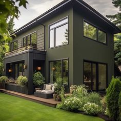 a house with lots of windows and plants in the yard