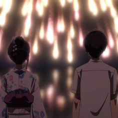 two people looking at fireworks in the sky with their backs turned to the camera,