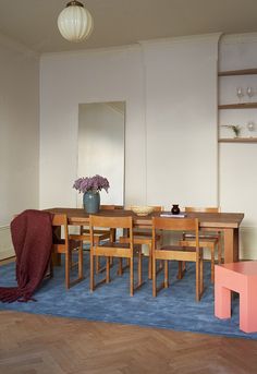 a dining room table and chairs with blue carpet