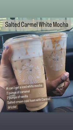 two cups of iced coffee sitting on top of a car dashboard next to each other