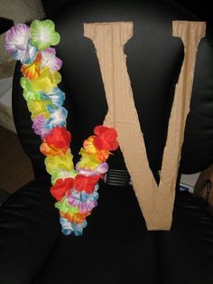 the letter v is decorated with flowers on it's back and sides in different colors