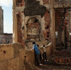 two men are standing in the ruins of an old building