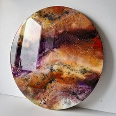 a plate that is sitting on top of a white surface with an orange and purple design