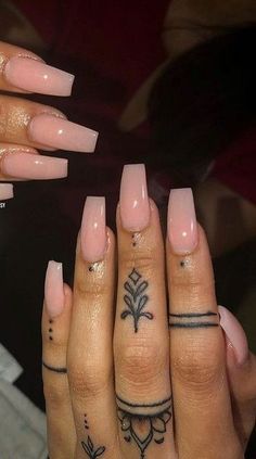 two hands with different tattoos on them and one has a flower tattoo on the middle finger