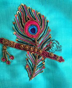 a close up of a peacock brooch on a blue cloth