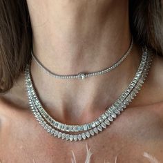 This magnificent tennis necklaces is designed with graduated sizes of Emerald Cut diamonds, a modern take on a classic style. Available in 18K White, Yellow and Rose Gold Diamond weight = 31.36 carats center stone = 1.20ct 2 stones = 0.70ct each 3 stones = 0.40ct each 8 stones = 0.55ct each 15 stones = 0.31ct each 31 stones = 0.25ct each 84 stones = 0.18 each Diamond quality = K/VS1+ Necklace length = 16in Luxury Diamond Cut Tennis Necklace For Everyday, Formal Diamond White Tennis Necklace With Baguette Diamonds, Elegant Diamond Tennis Necklace With Baguette Diamonds, Diamond White Cubic Zirconia Tennis Necklace With Baguette Diamonds, Diamond White Baguette Cubic Zirconia Tennis Necklace, Diamond Baguette Cut Tennis Necklace, Formal Diamond White Baguette Diamonds Tennis Necklace, Baguette Cut Diamond Tennis Necklace, White Gold Tennis Necklace With Baguette Diamonds For Anniversary