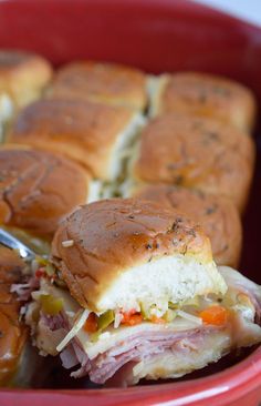 a close up of a sandwich in a red bowl with a toothpick sticking out of it