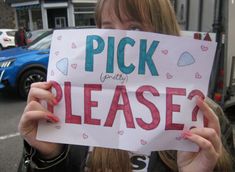 a woman holding up a sign that says pick party please on the side of her face