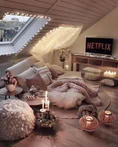 a living room filled with lots of furniture and lights on the ceiling above it's windows