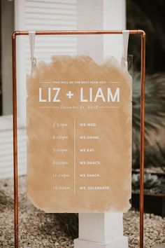 a sign that says liz + llam on it in front of a white building