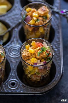 four glasses filled with food sitting on top of a tray