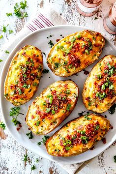 baked potatoes with cheese and herbs on a white plate