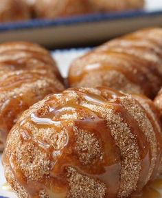 cinnamon buns with icing and sugar on them sitting on a blue and white plate