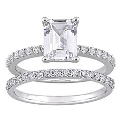 an emerald - cut diamond ring and matching wedding band are featured in this white gold engagement set