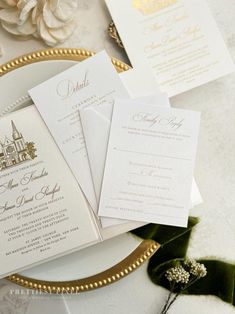 the wedding stationery is laid out on a plate