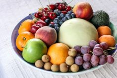 a bowl filled with assorted fruits and vegetables